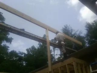 Carpenter setting a ridge beam over a new addition frame — Ice Dam Removal by Roofing Brothers in Blue Rock