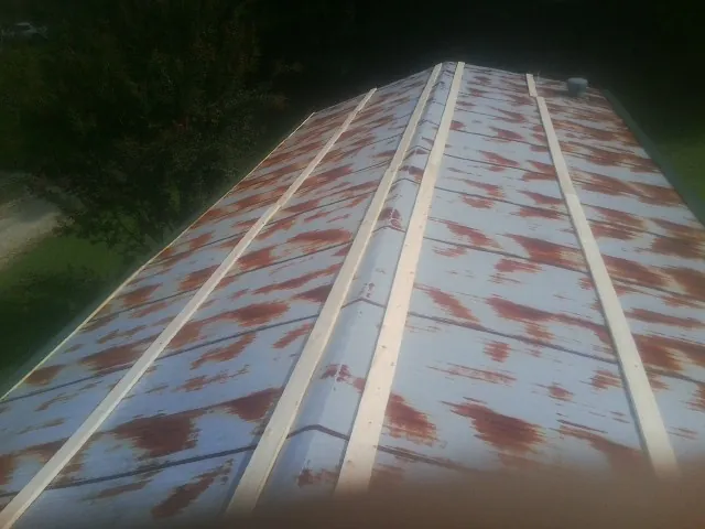 Rusted metal roof panels with new wood purlins before replacement — Storm Damage Roof Repair in Blue Rock by Roofing Brothers