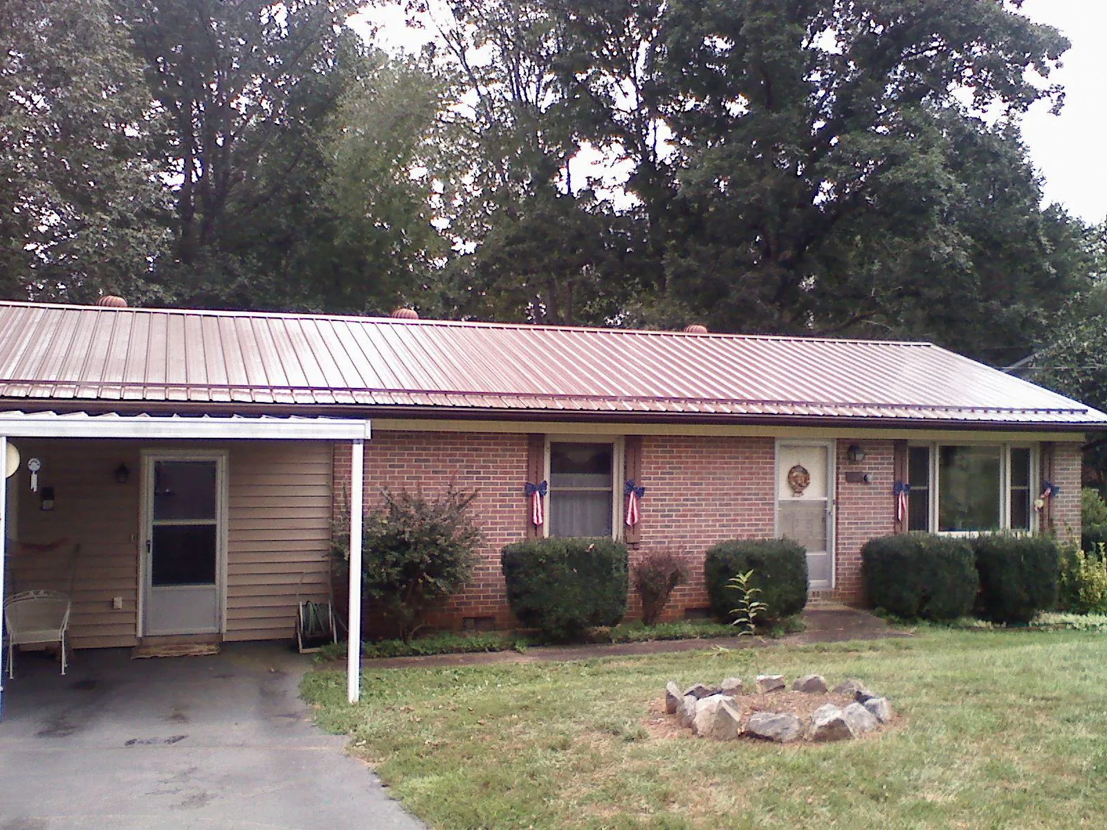 Bronze metal roof and carport on a brick ranch home — Roof Repair work by our crew in Blue Rock